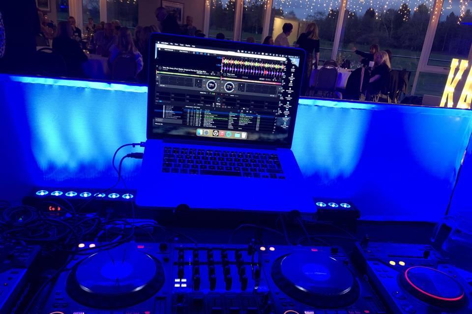 Professional DJ decks and laptop with blue lighting
