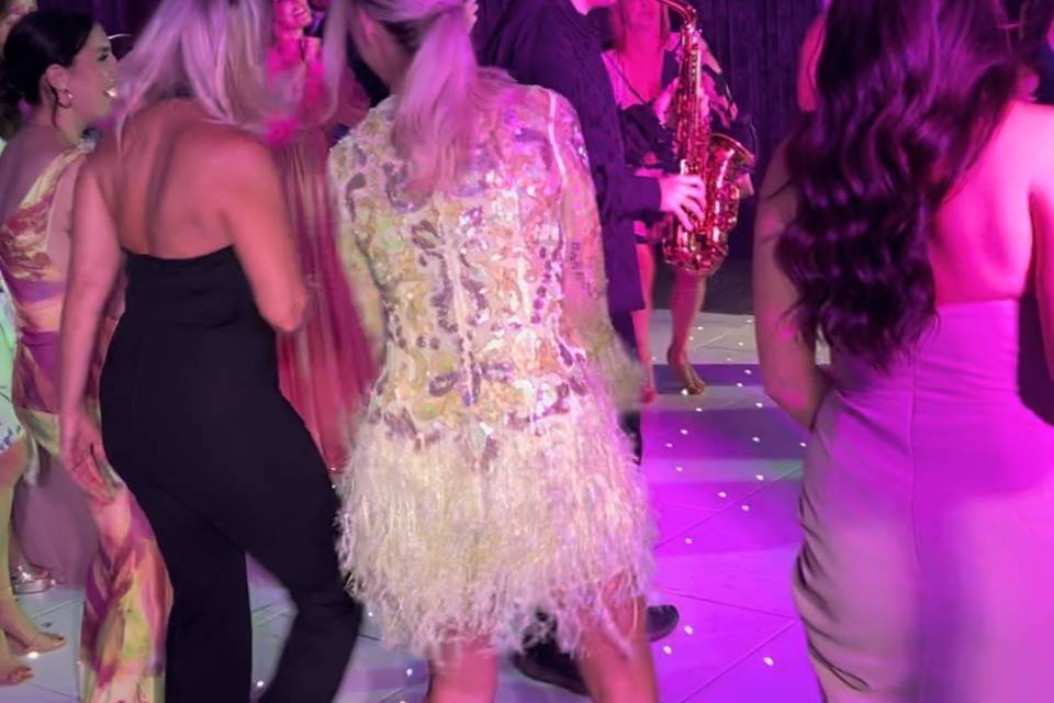 Live saxophonist performing with guests on a wedding dancefloor